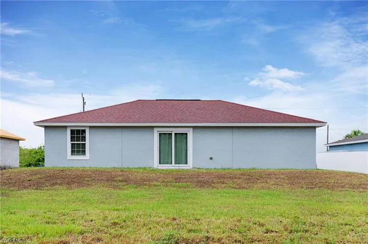 Back of property featuring a lawn