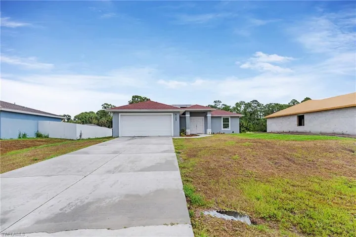 Ranch-style home with a front yard and a garage