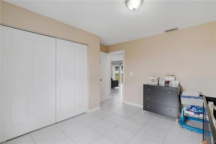 Tiled bedroom with a closet