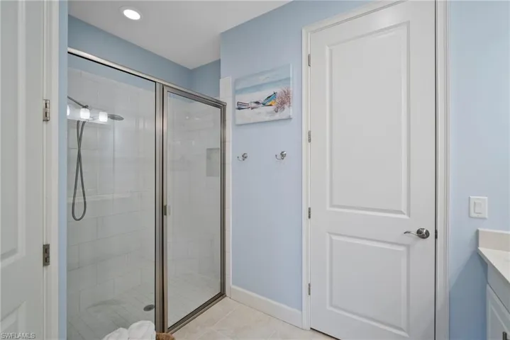 Bathroom with vanity, tile patterned floors, and a shower with door