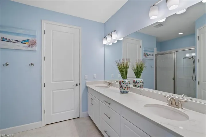 Bathroom with vanity, tile patterned flooring, and a shower with door