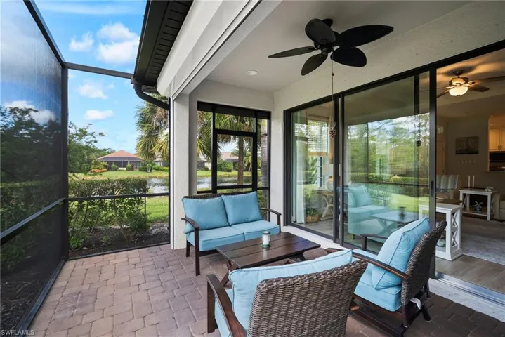 Sunroom / solarium featuring a water view and ceiling fan