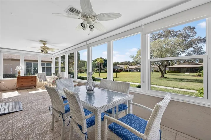Sunroom with outdoor dining space and a ceiling fan