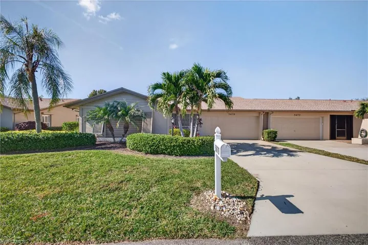 Ranch-style house featuring concrete driveway, a front yard, and an attached garage