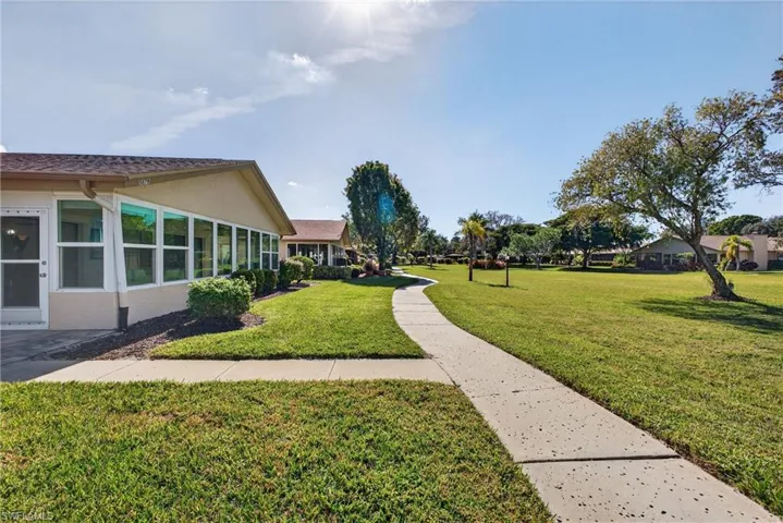 View of property's community featuring a lawn and a sunroom