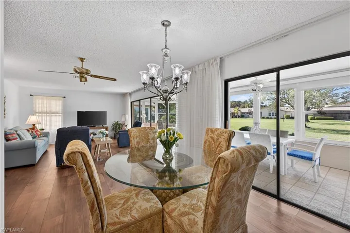Dining area featuring a ceiling fan, a textured ceiling, a chandelier, and hardwood / wood-style flooring