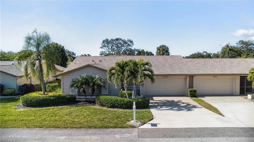 Ranch-style home featuring concrete driveway and a front lawn