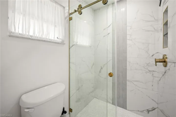 Primary bathroom with tiled glass wall shower