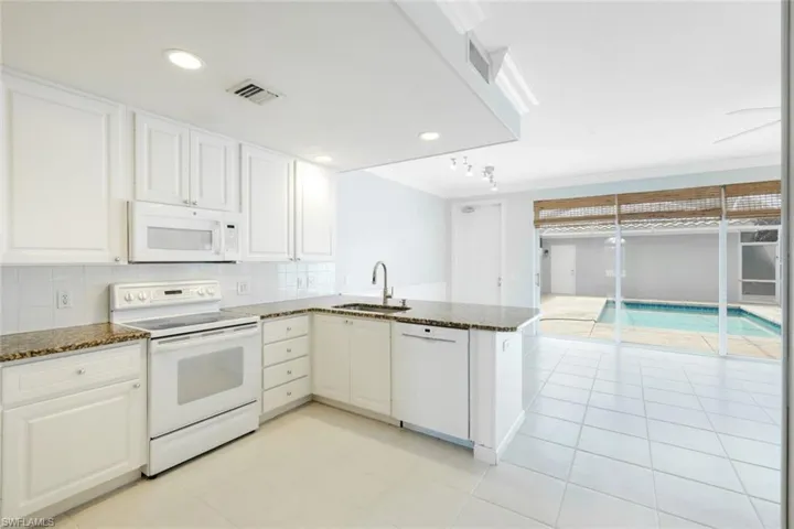 Modern kitchen with white cabinetry and integrated appliances