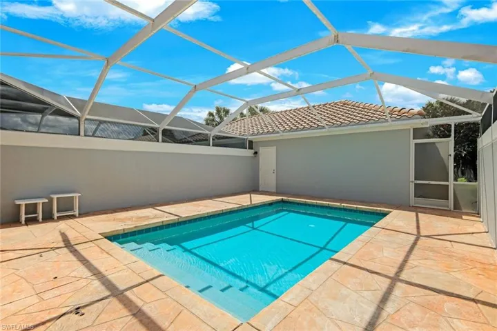 Screened enclosure featuring a rectangular pool with steps