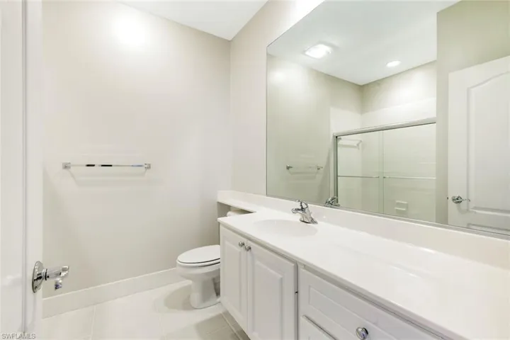 Bathroom featuring a spacious vanity with an integrated sink, polished chrome faucet, and white cabinetry