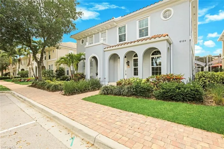 Mediterranean-style residence featuring a tile roof, stucco exterior, arched entryway, and circular window