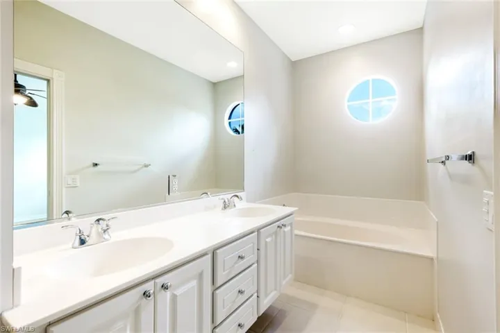 Double vanity with white cabinetry, dual sinks, and chrome faucets