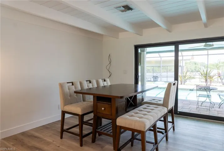 Dining room featuring baseboards, beam ceiling, visible vents, and light wood-type flooring