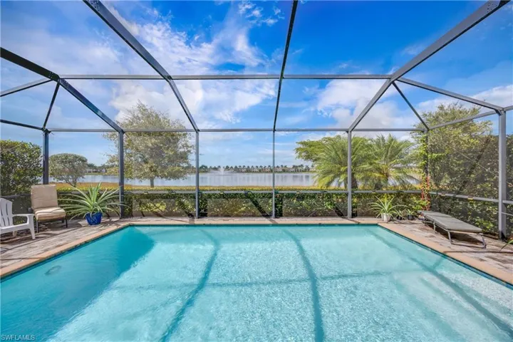 Swimming pool featuring a sunroom, a water view, a lanai, and a patio area