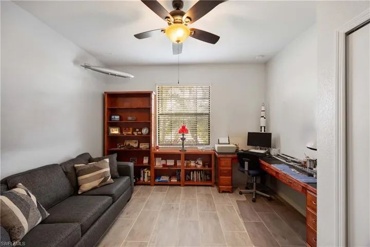 Made into an Office with built in study area, ceiling fan, and wood finish floors