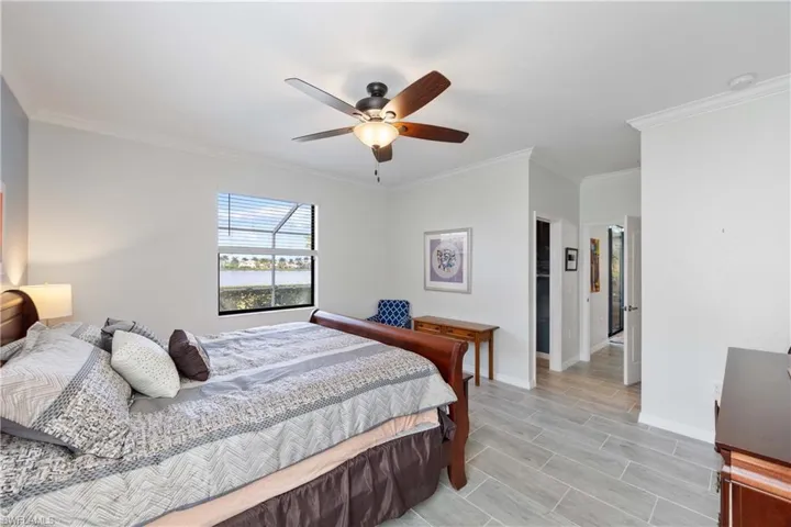 Guest Bedroom with crown molding, ceiling fan, a closet, and wood tiled floors