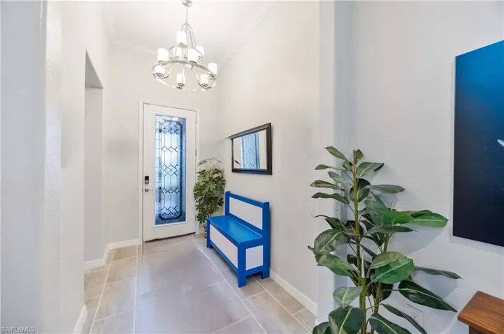 Entryway featuring crown molding and suspended lighting