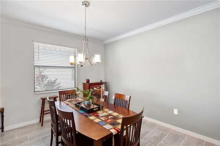Dining space featuring ornamental molding, wood tiled floors, and suspended lighting