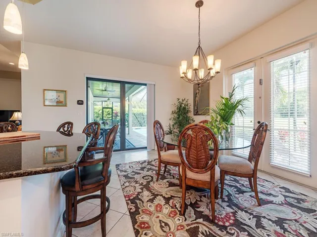 Dining area with a wealth of natural light, a notable chandelier, and light tile patterned floors