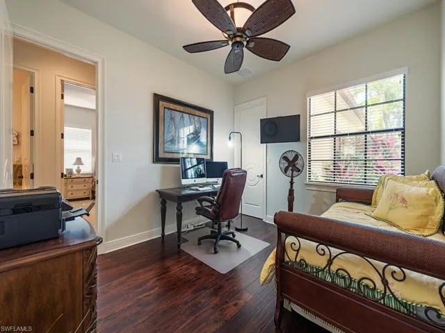 Office with wood finished floors, a ceiling fan, and baseboards