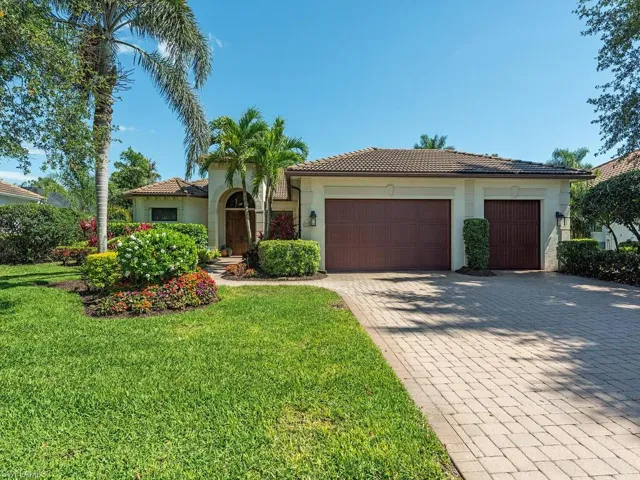 View of front of house featuring a tiled roof, a garage, a front yard, stucco siding, and decorative driveway