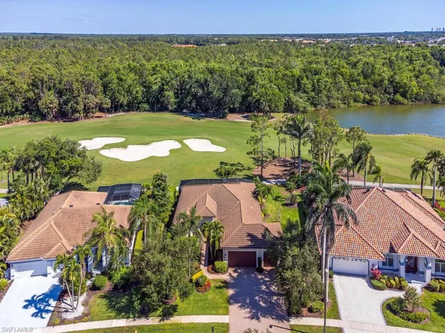 Aerial view with view of golf course, a view of trees, and a water view