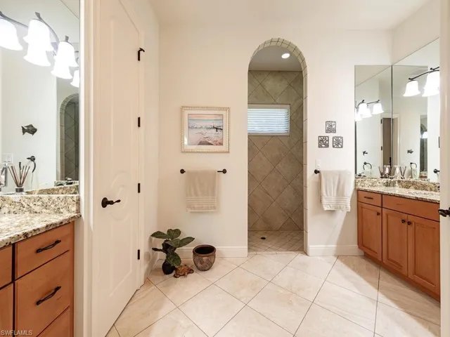Full bathroom featuring walk in shower, vanity, tile patterned floors, and baseboards