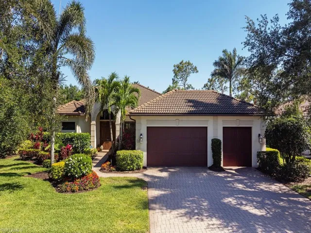 View of front of house with an attached garage, a tiled roof, decorative driveway, and stucco siding