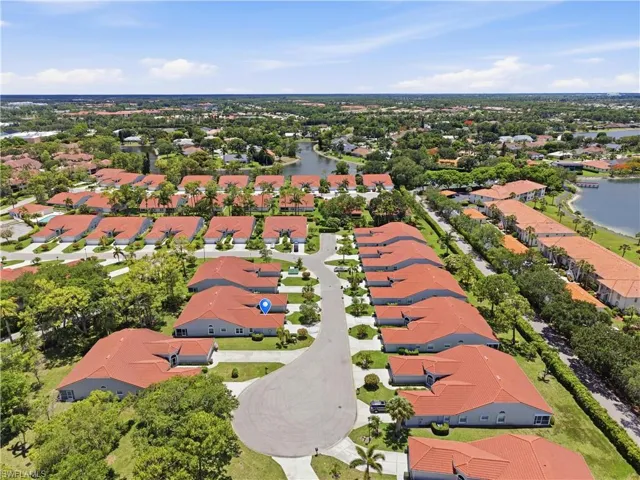 Aerial perspective of a community featuring numerous residences with red tile roofs and mature landscaping