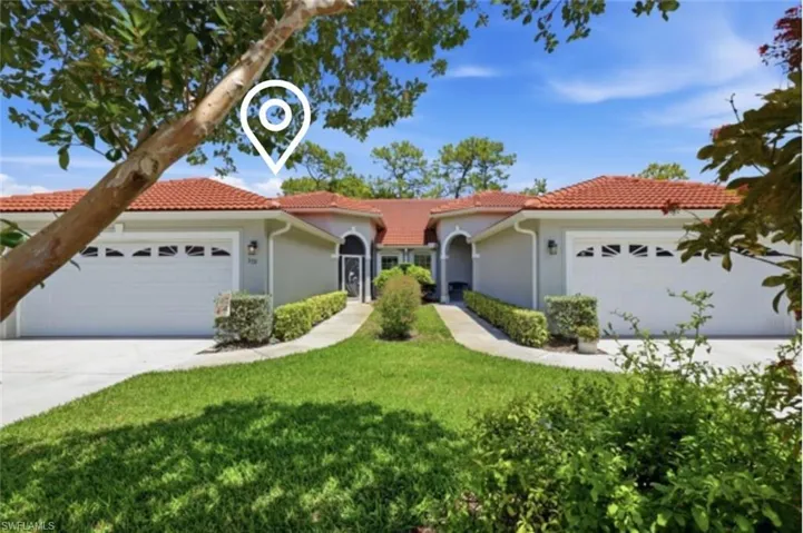 Twin villa residence featuring terracotta-style roof tiles, stucco exterior, and two separate single-car garages with decorative windows