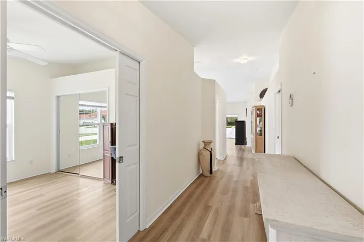 Interior hallway featuring wood-finish flooring, light-colored walls, and a recessed ceiling light