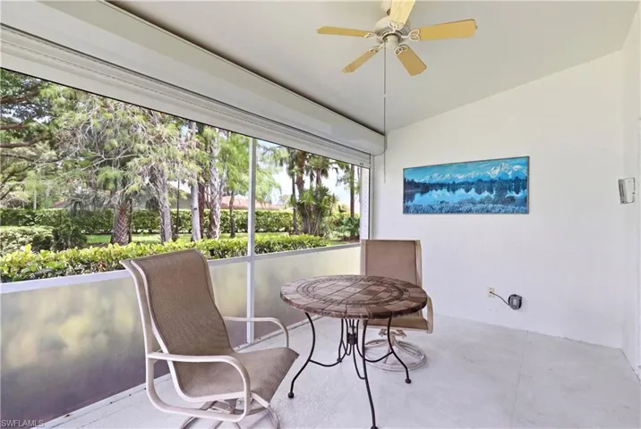 Screened patio featuring a ceiling fan, white walls, and a light-colored floor