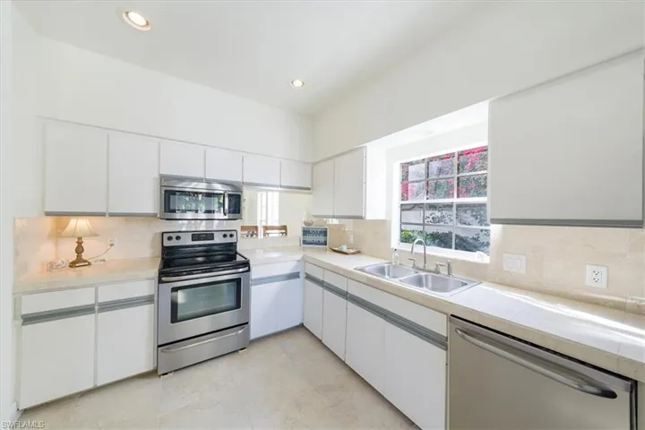 Kitchen with  window looking out to beautiful bouganvillea trees