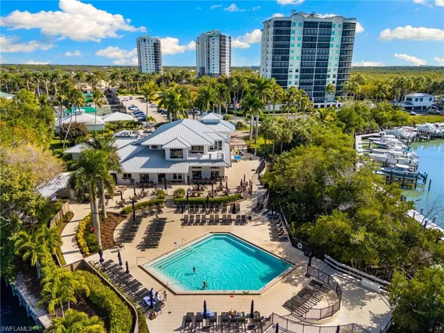 Community pool featuring a patio area, a water view, and stairs