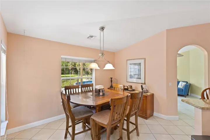 Dining space featuring light tile patterned floors and arched walkways