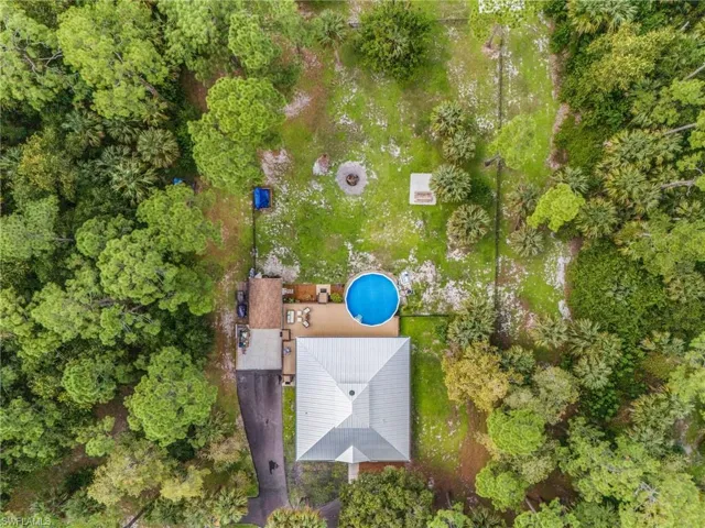 Aerial view of property and surrounding area featuring a pool area