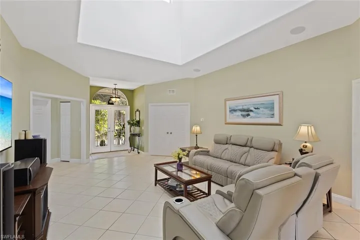 Living area with french doors, a high ceiling, and light tile patterned floors