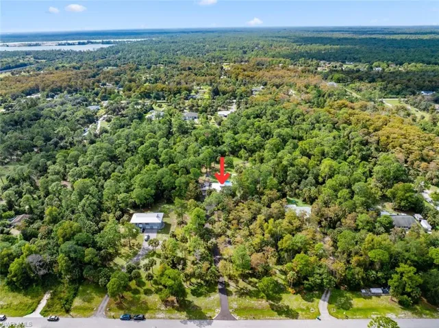 View of property location with a forest and a nearby body of water