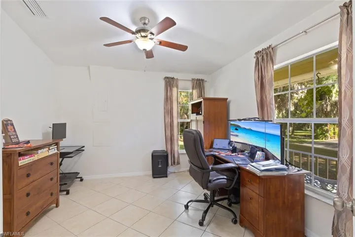 Office with light tile patterned floors and a ceiling fan