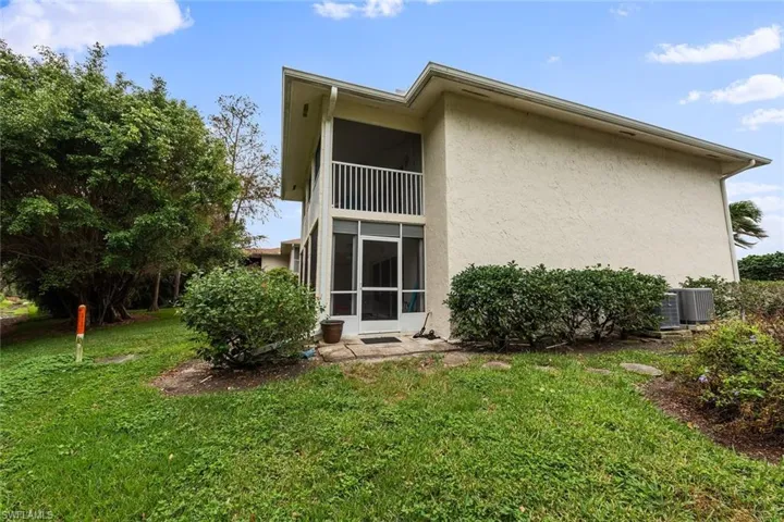 Rear view of property with a yard and central air condition unit