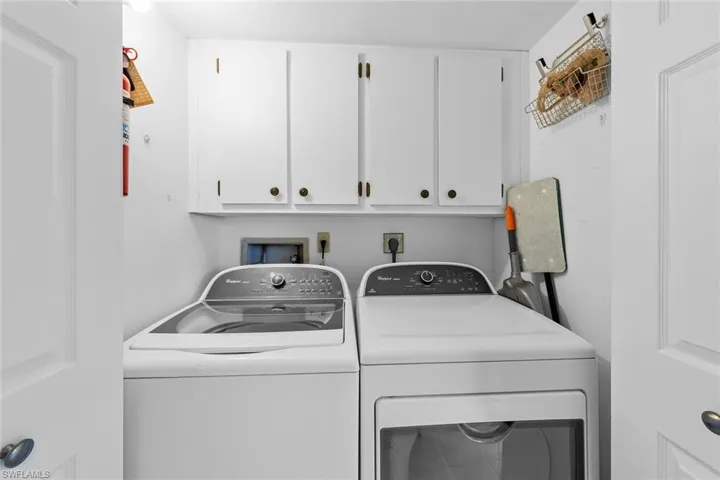 Washroom with cabinets and separate washer and dryer