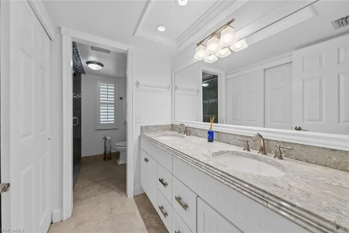 Bathroom featuring vanity, toilet, and ornamental molding