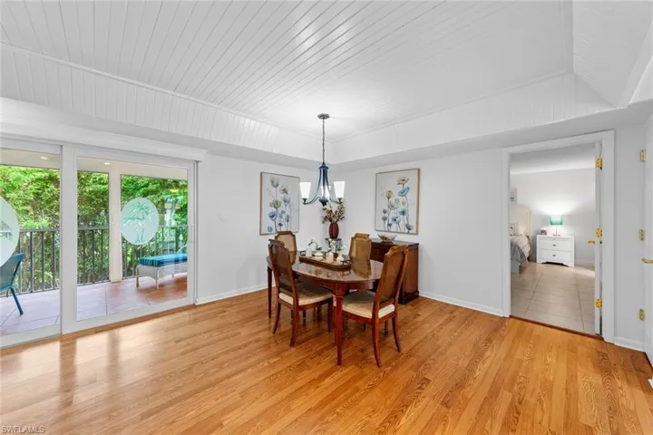 Dining room with wood ceiling, light hardwood / wood-style flooring, a chandelier, and lofted ceiling