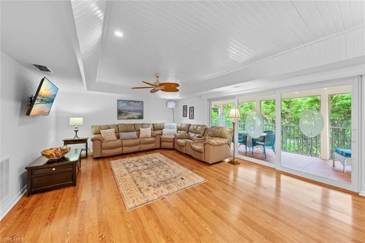 Living room with ceiling fan and light hardwood / wood-style floors