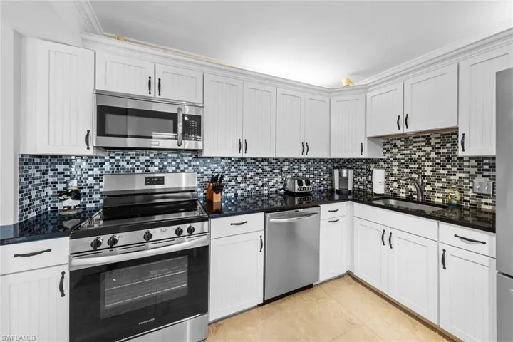 Kitchen with sink, white cabinets, and stainless steel appliances