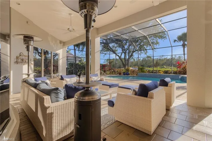 View of patio with ceiling fan, glass enclosure, and an outdoor hangout area