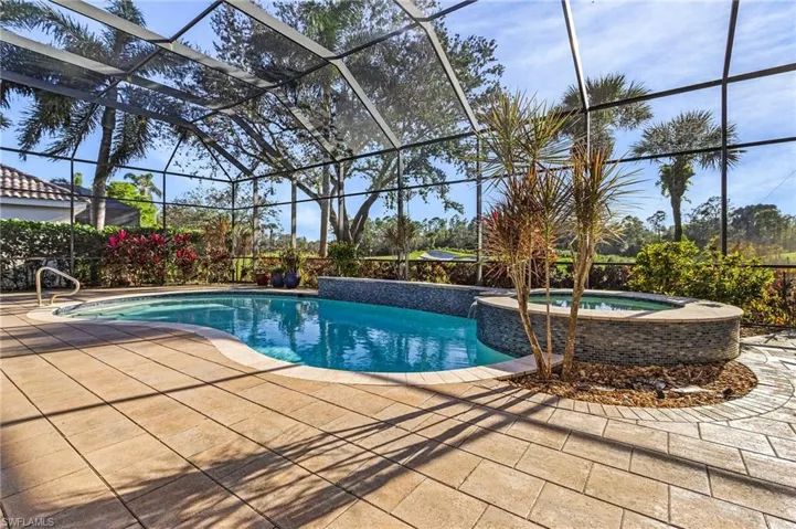View of swimming pool with an in ground hot tub, a patio, and a lanai