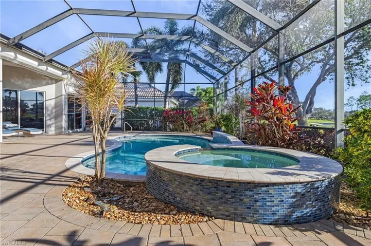 View of swimming pool featuring a patio, an in ground hot tub, and glass enclosure