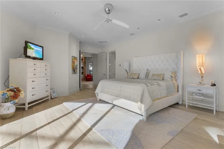 Bedroom featuring ceiling fan, light hardwood / wood-style flooring, and ornamental molding